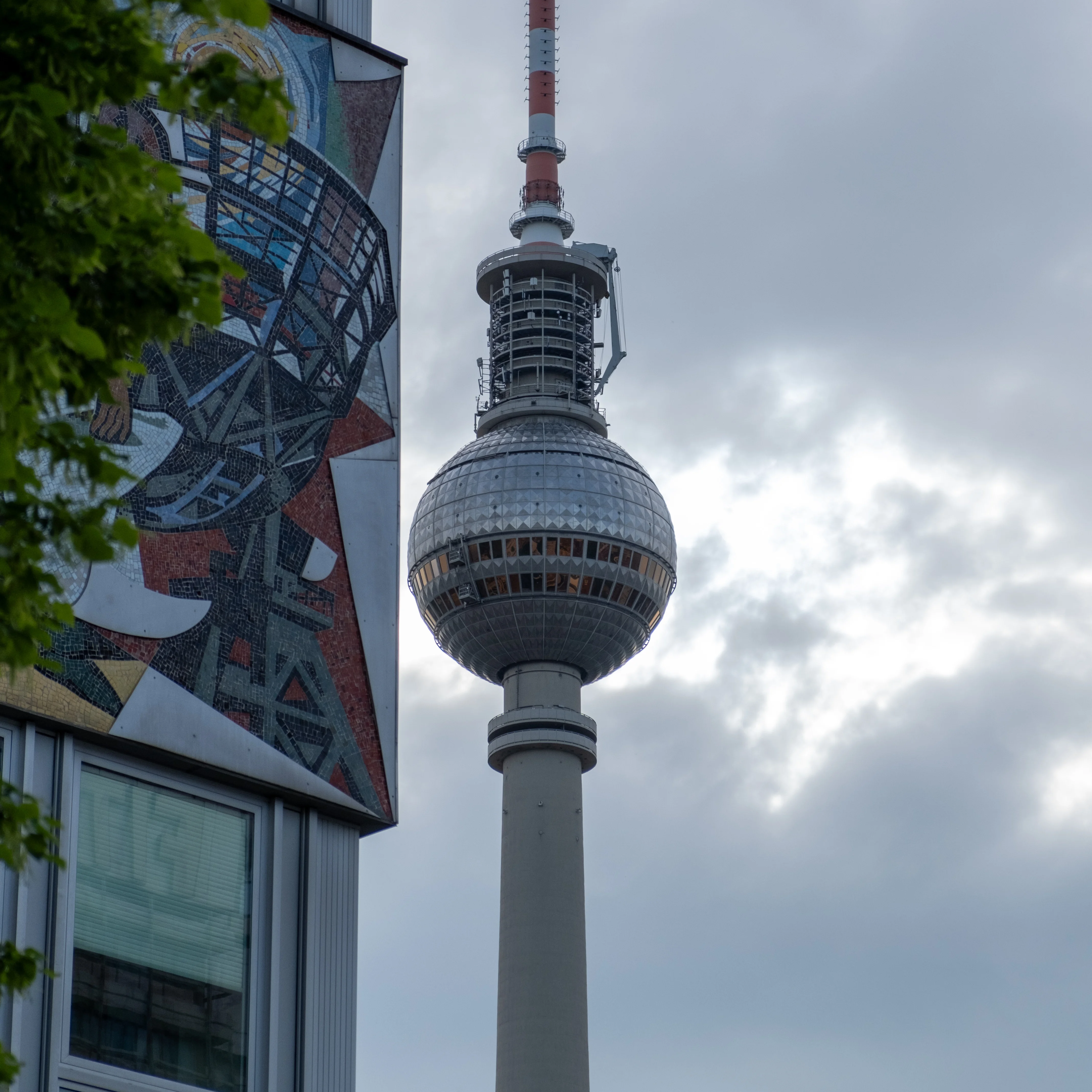 55mm · f/4 · 1/1600s · ISO 200
FUJIFILM X-T5 · XF18-55mmF2.8-4 R LM OIS · Apr 28, 2024
Berlin TV Tower next to a large colorful mosaic mural.
Berlin, Germany
© Brandon Cook