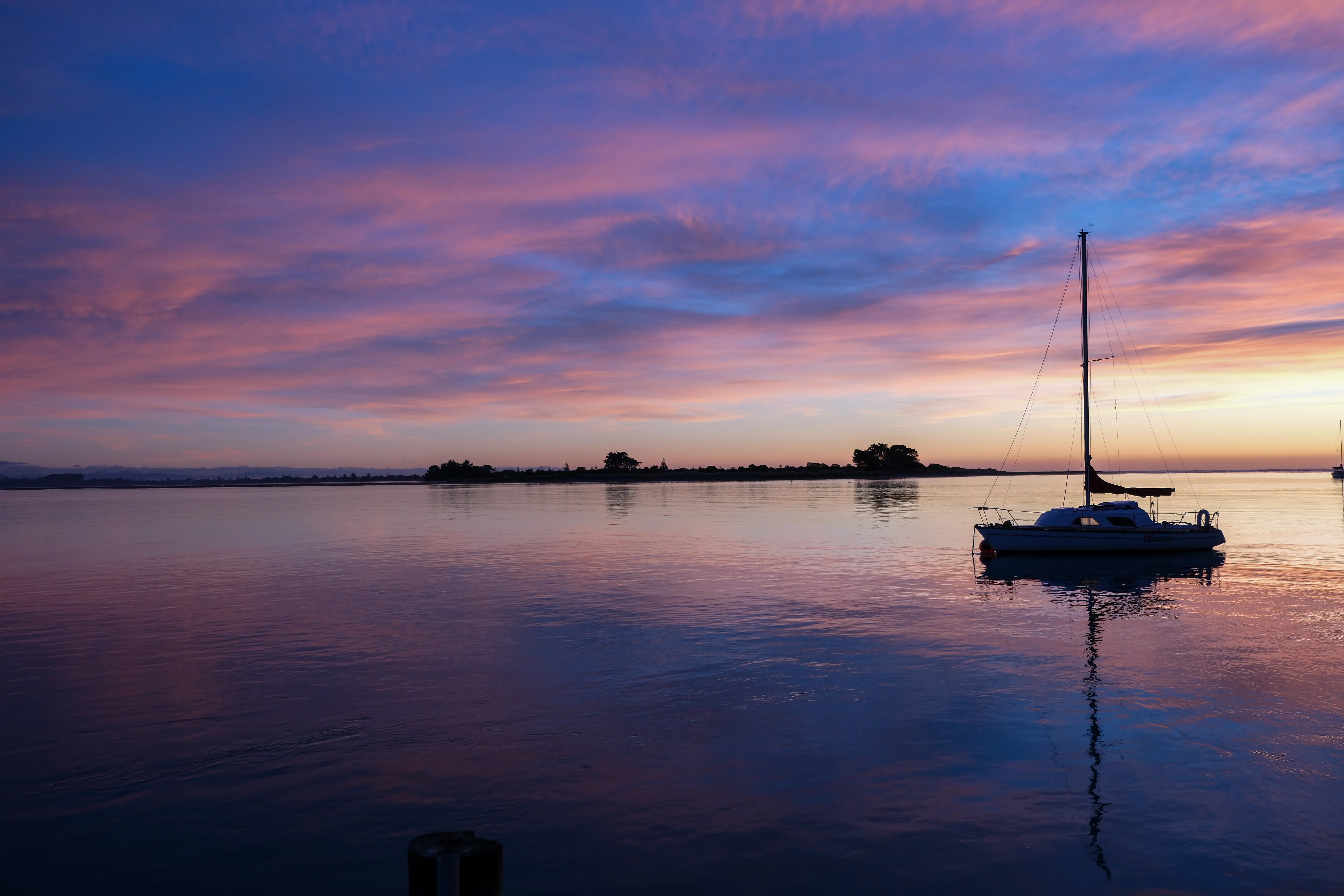 18mm · f/2.8 · 1/400s · ISO 400
FUJIFILM X-T5 · XF18-55mmF2.8-4 R LM OIS · May 24, 2024
Sailboat on calm Christchurch water beneath a colorful sunrise sky.
Christchurch, New Zealand
© Brandon Cook