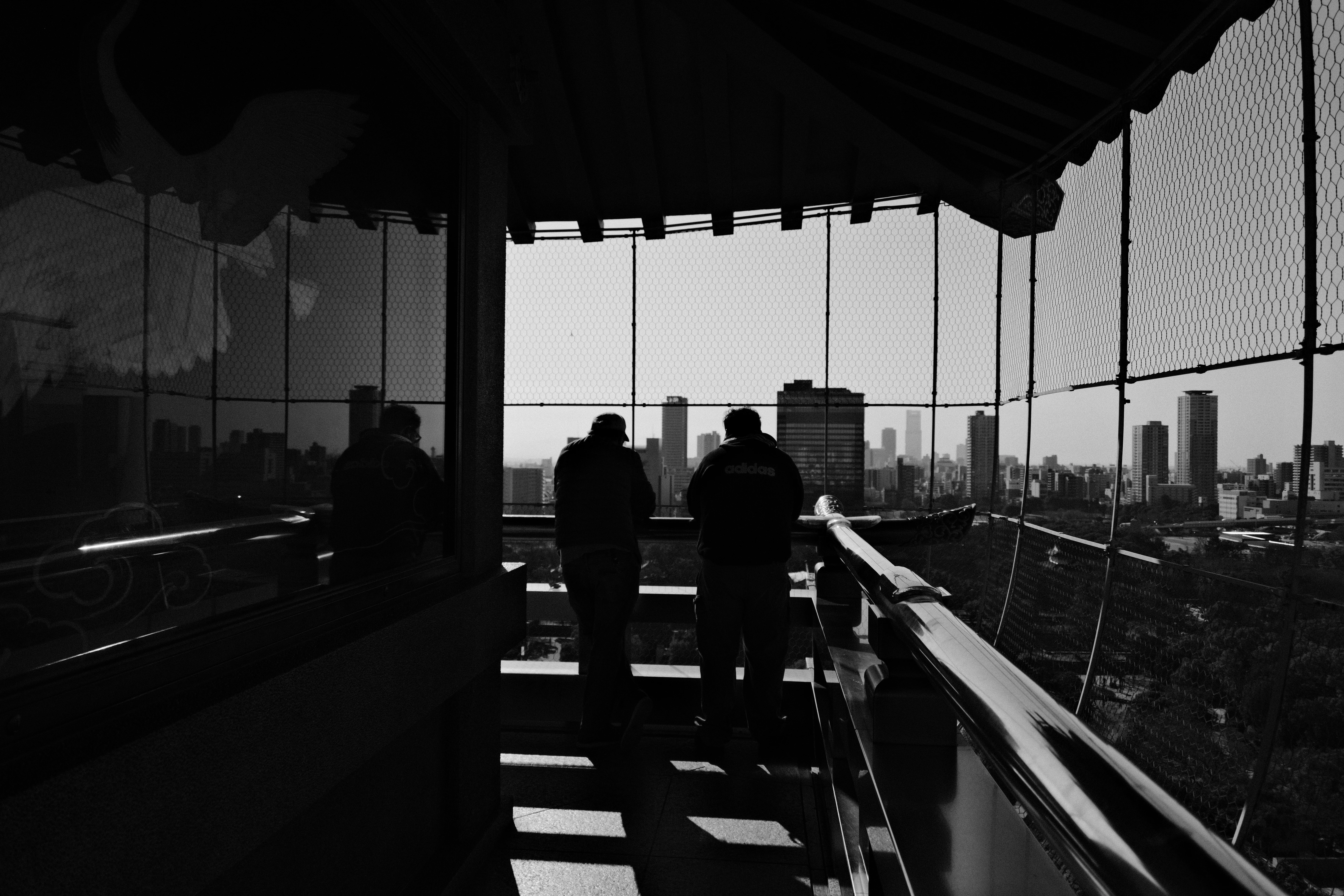 16mm · f/3.5 · 1/5000s · ISO 250
FUJIFILM X-T5 · 16-300mm F3.5-6.7 DC OS | Contemporary 025 · Jan 7, 2026
Silhouetted figures overlook the Osaka skyline from a traditional balcony.
Osaka, Japan
© Brandon Cook