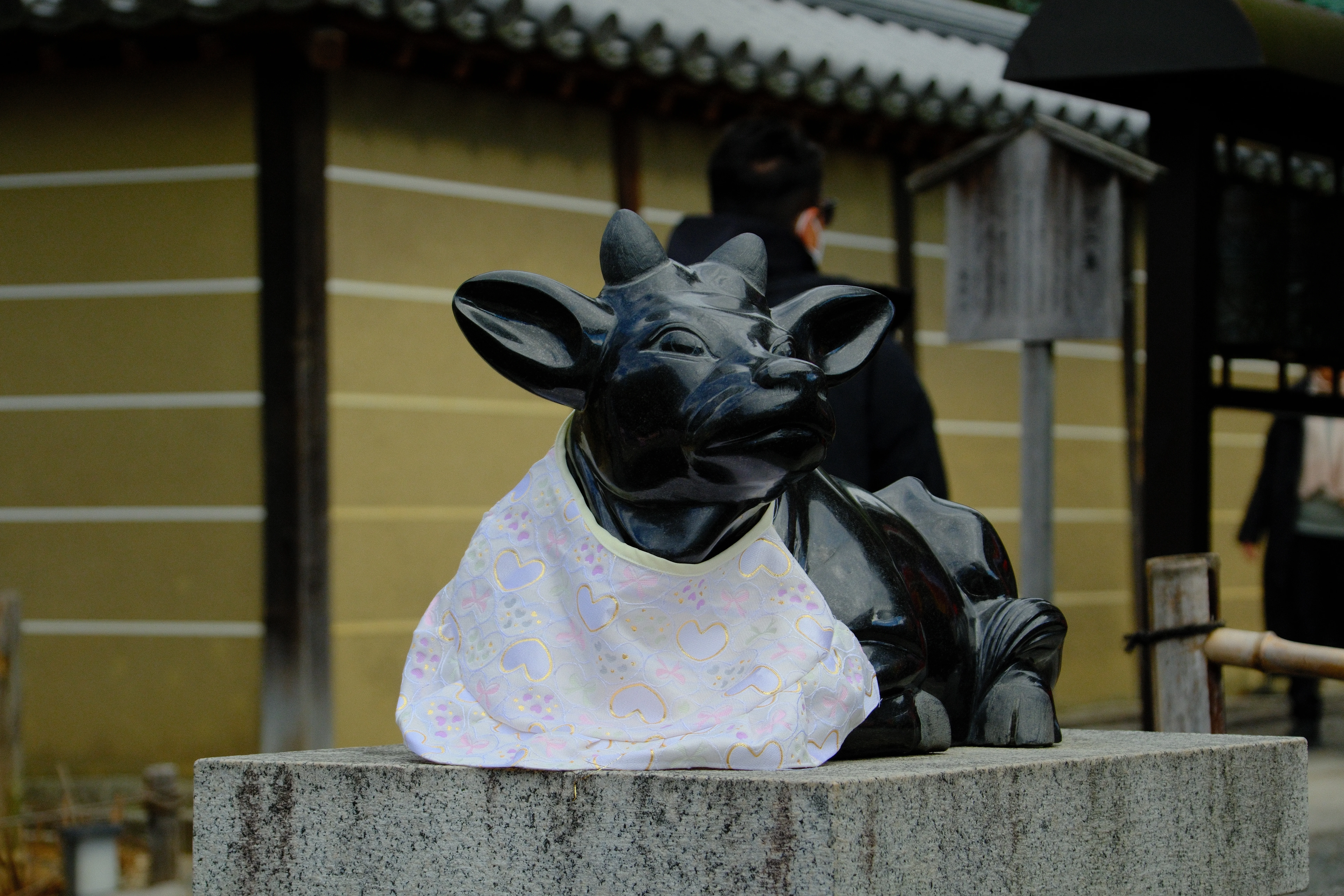 71mm · f/5.6 · 1/800s · ISO 500
FUJIFILM X-T5 · 16-300mm F3.5-6.7 DC OS | Contemporary 025 · Jan 10, 2026
Black stone ox statue with a heart bib in Kyoto.
Kyoto, Japan
© Brandon Cook