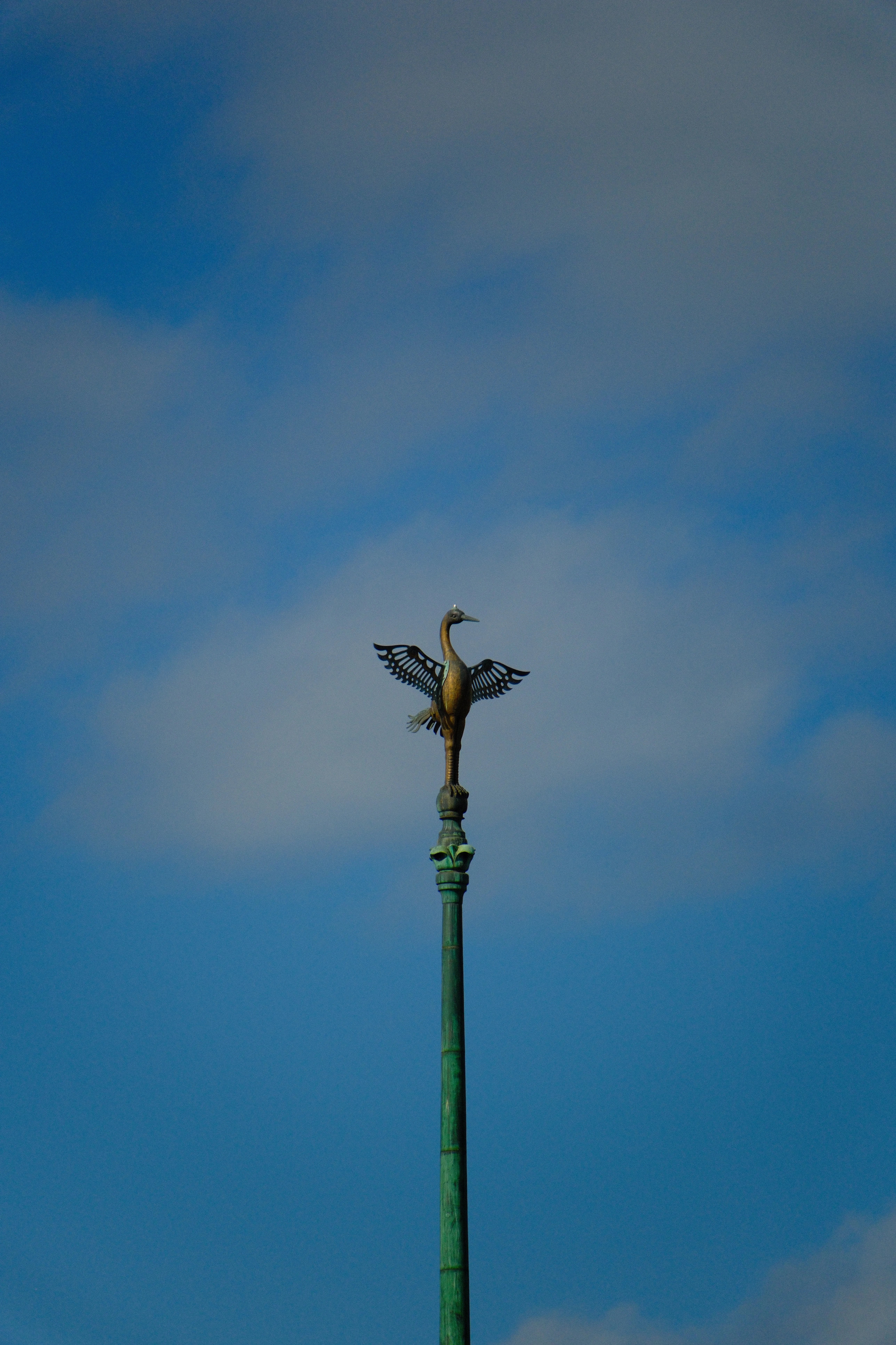 300mm · f/6.7 · 1/3500s · ISO 500
FUJIFILM X-T5 · 16-300mm F3.5-6.7 DC OS | Contemporary 025 · Jan 10, 2026
Bronze bird sculpture on a green pole against blue sky.
Kyoto, Japan
© Brandon Cook