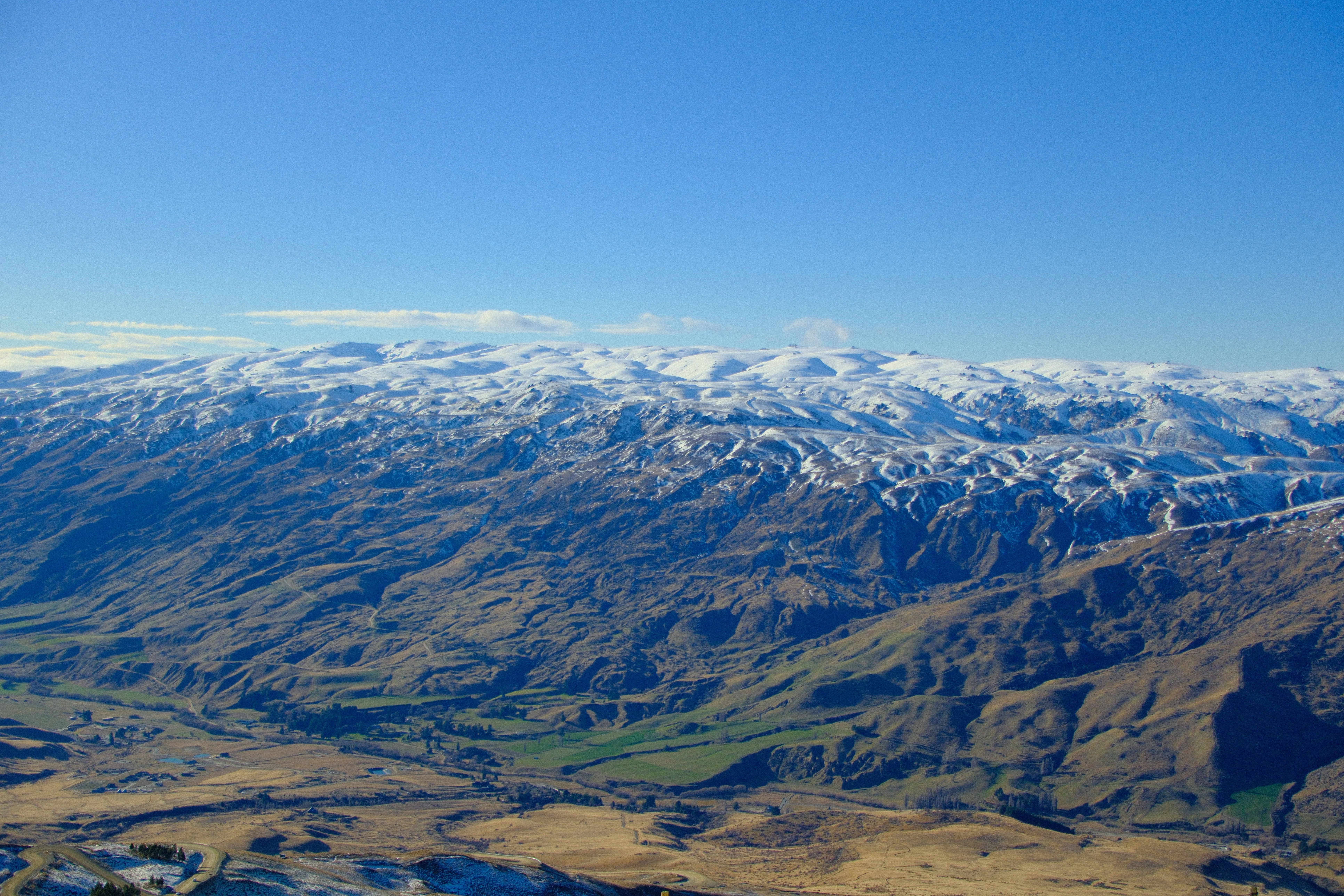 30mm · f/4.5 · 1/3200s · ISO 500
FUJIFILM X-T5 · 16-300mm F3.5-6.7 DC OS | Contemporary 025 · Jul 22, 2026
Snow-capped mountains tower over the New Zealand countryside.
Crown Range, New Zealand
© Brandon Cook
